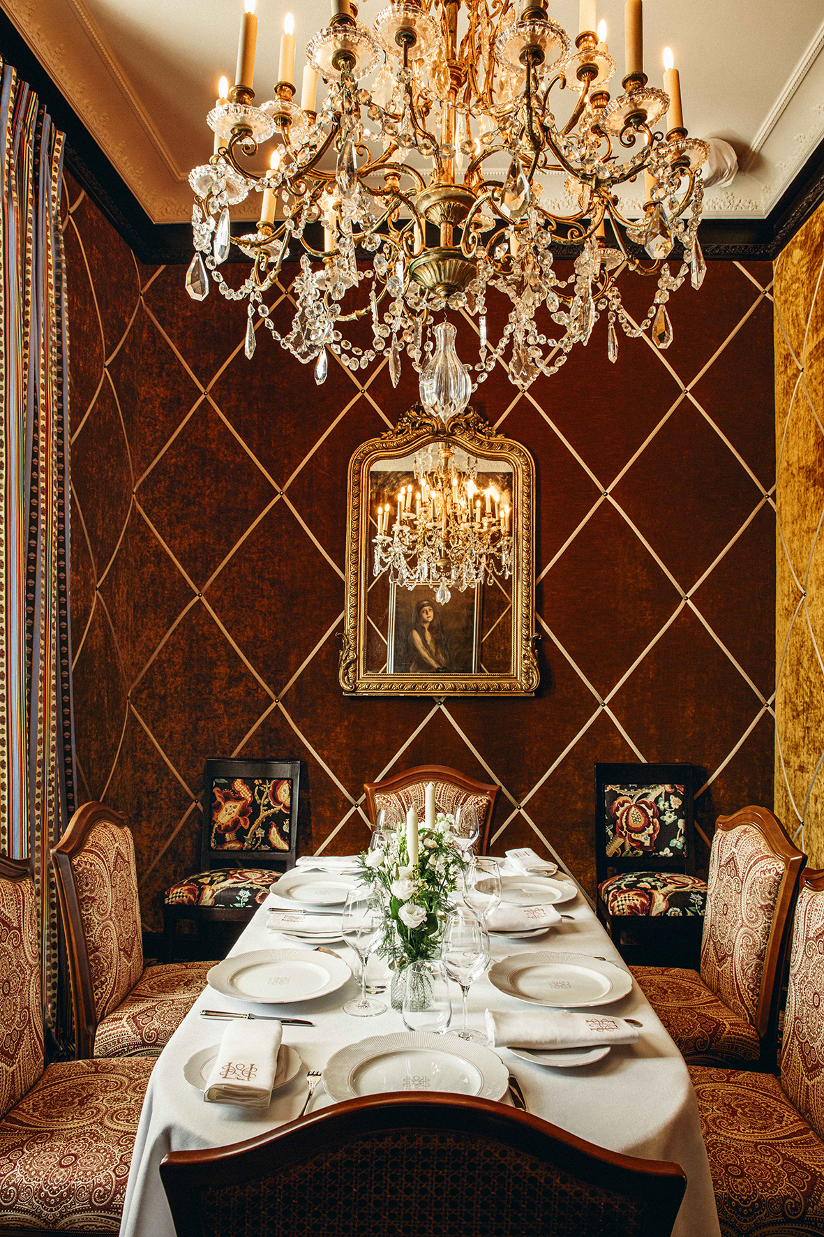 Agencement de restaurant avec mobilier bois et assises tissu, table dressée et décoration murale textile