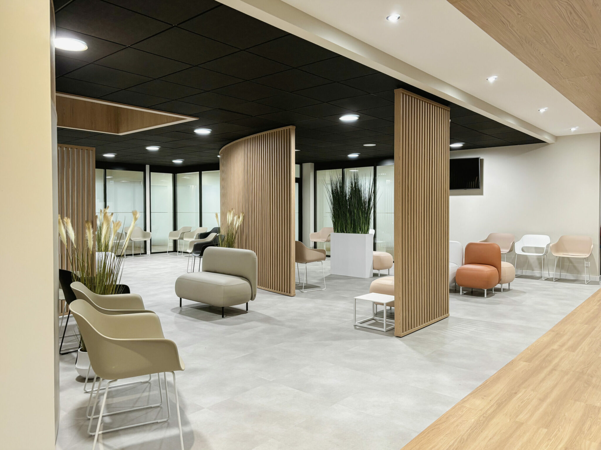 Salle d’attente de centre médical avec claustras bois sur mesure, afin de créer des espaces confidentiel, assises