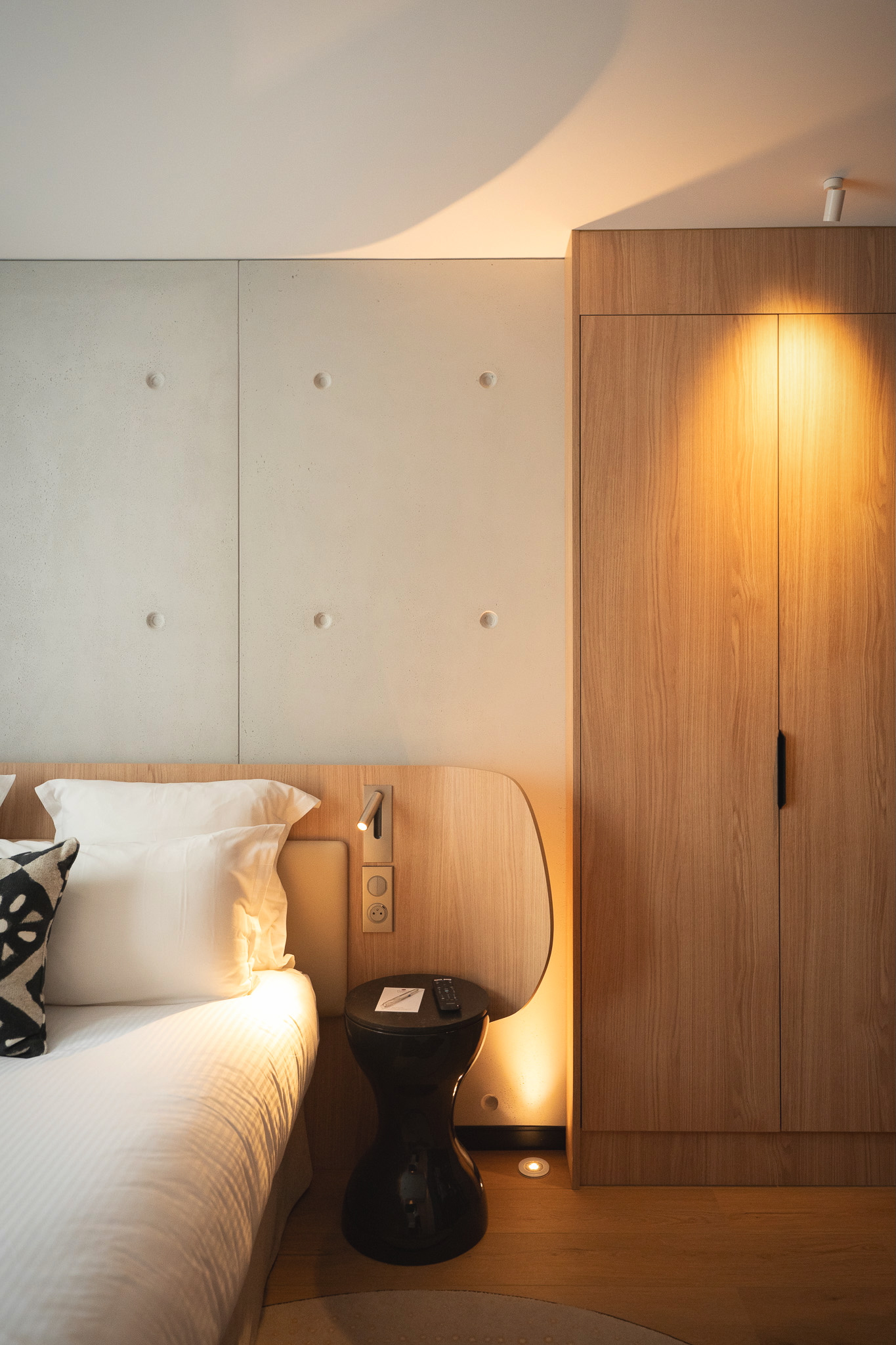 Détail sur le mur en béton, dressing en bois détails de la poignées en marbre  Mobilier de chambre sur mesure avec tête de lit arrondies en bois